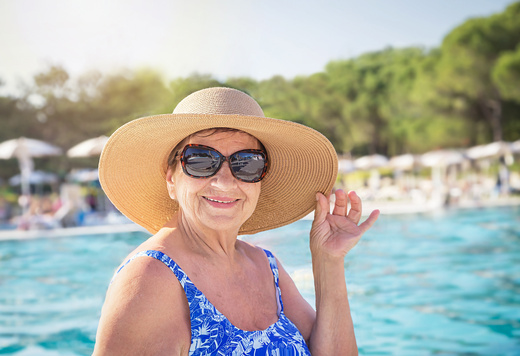 Senior women (over age of 50) relaxing in resort swimming pool.